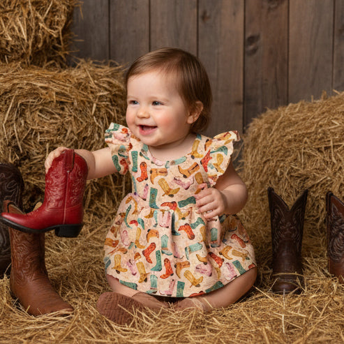 Baby sitting in Barn with Boot Print Romper