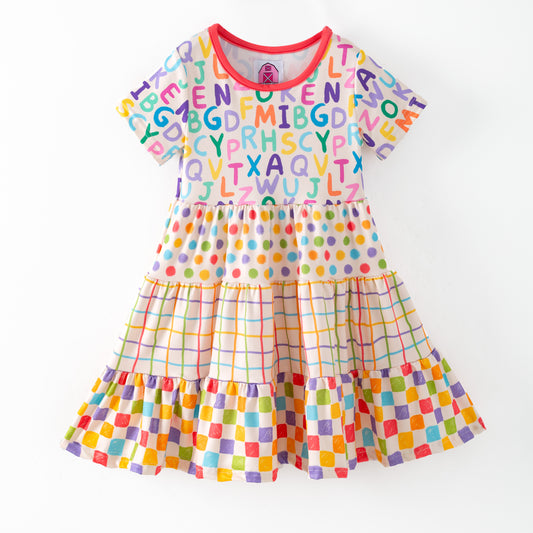 Colorful children's dress with alphabet pattern on a white background