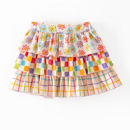 Colorful tiered skirt with floral and checkered patterns on a white background