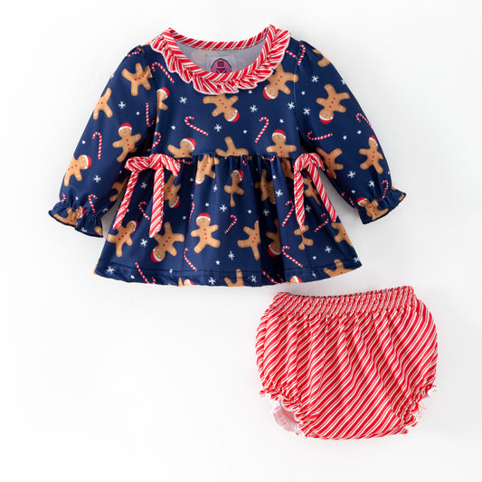 Children's Christmas-themed outfit with gingerbread pattern and candy cane details on a blue background
