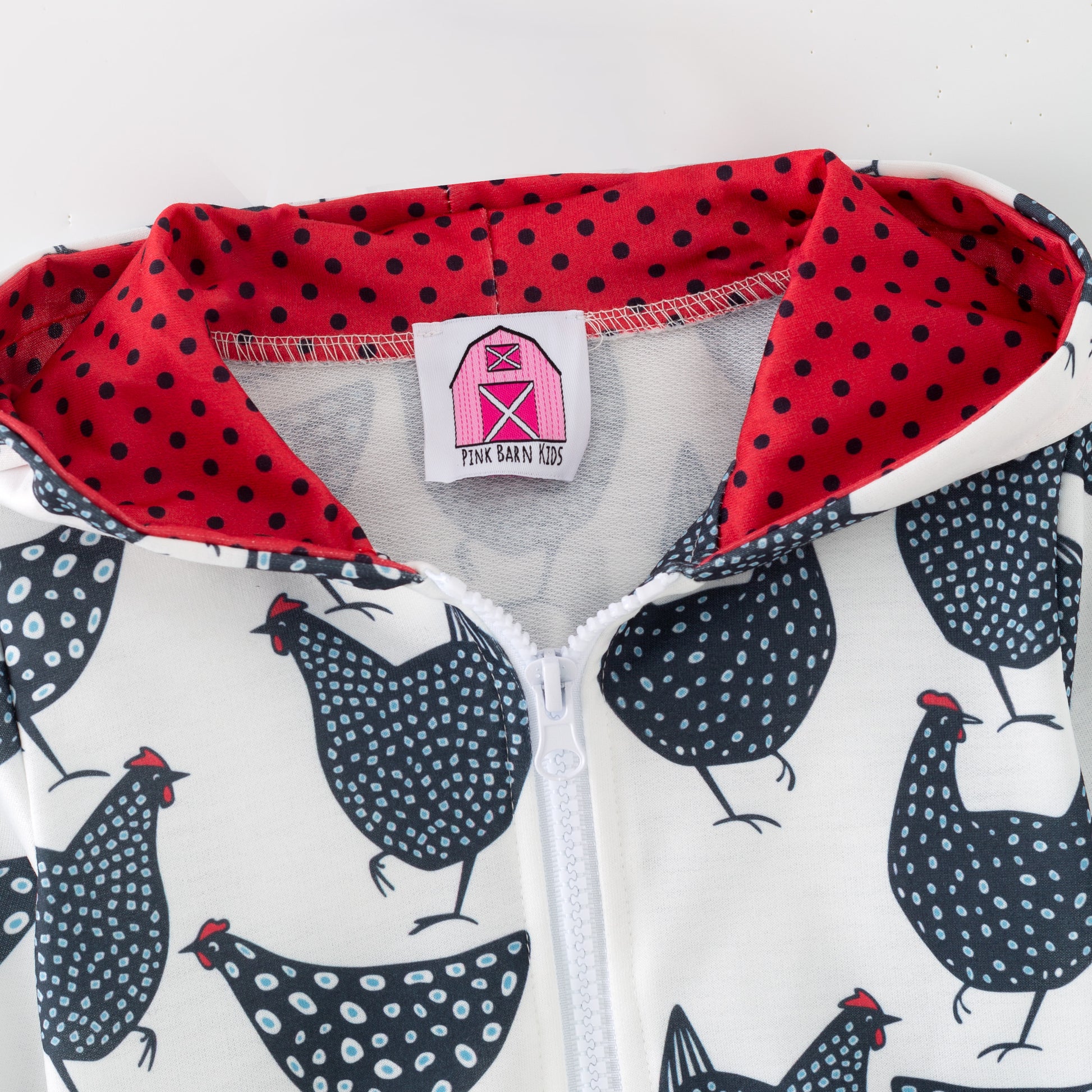 Children's hoodie with chicken pattern and red polka dot interior on a white background
