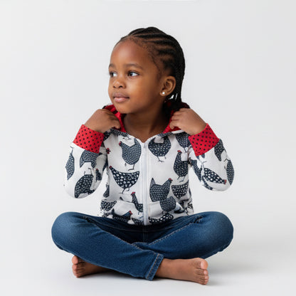 Child wearing a hoodie with chicken pattern and red cuffs on a white background