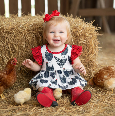Child in a farm setting with chickens and hay
