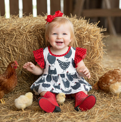 Child in a farm setting with chickens and hay