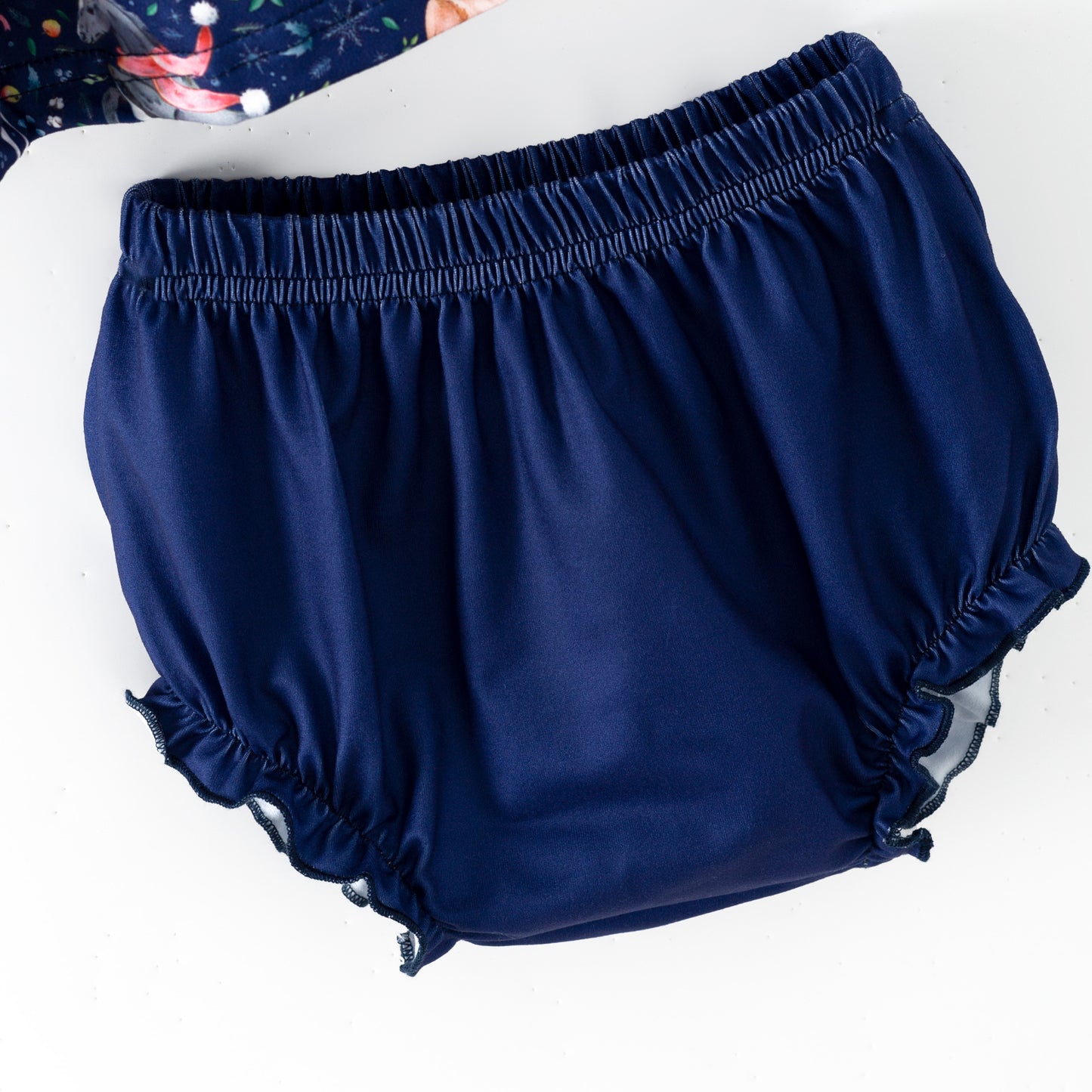 Navy blue baby bloomers on a white background