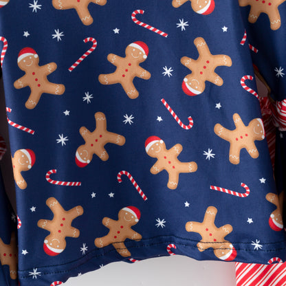Christmas-themed fabric with gingerbread men, candy canes, and snowflakes on a blue background.