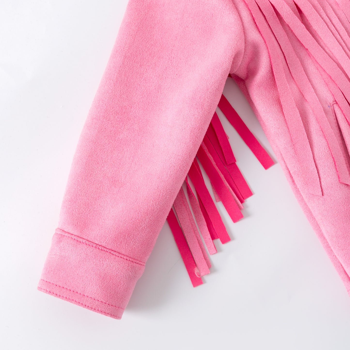 Close-up of a pink fabric with fringe on a white background