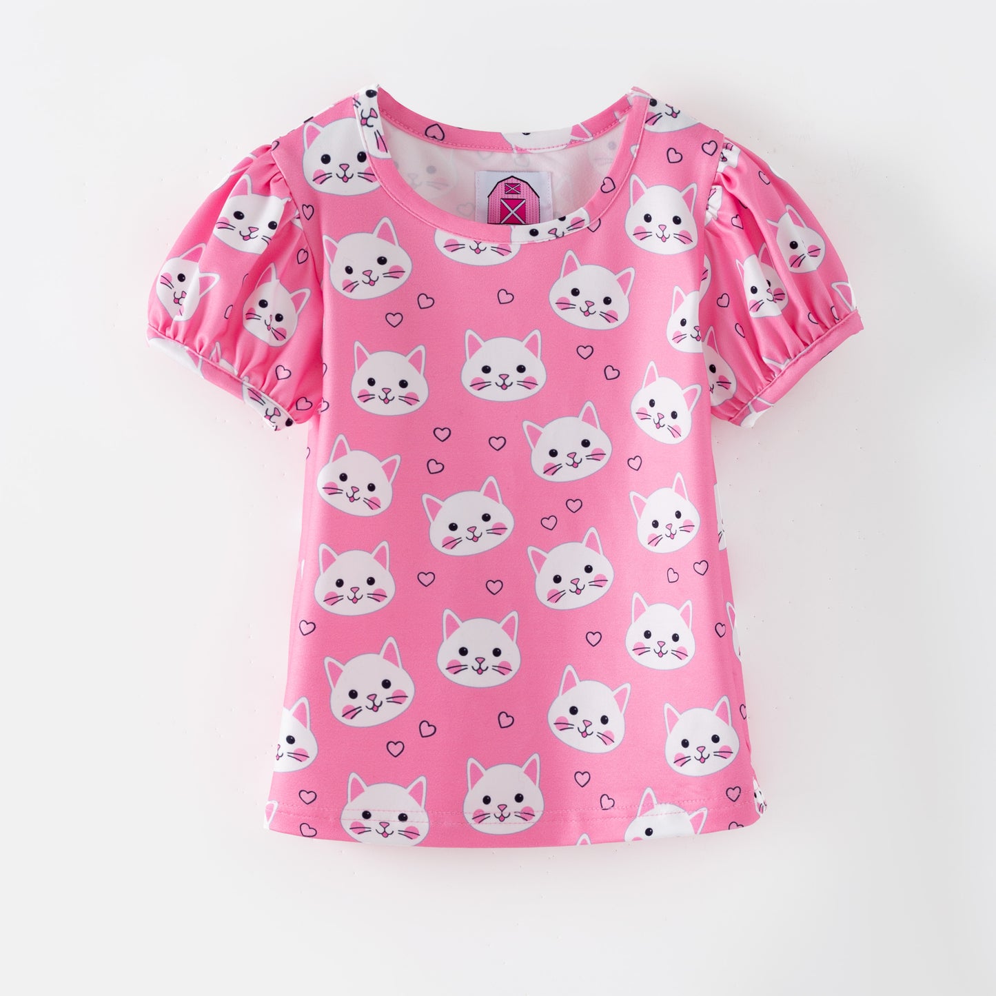 Pink children's puffed sleeve top with cat pattern on a pink background