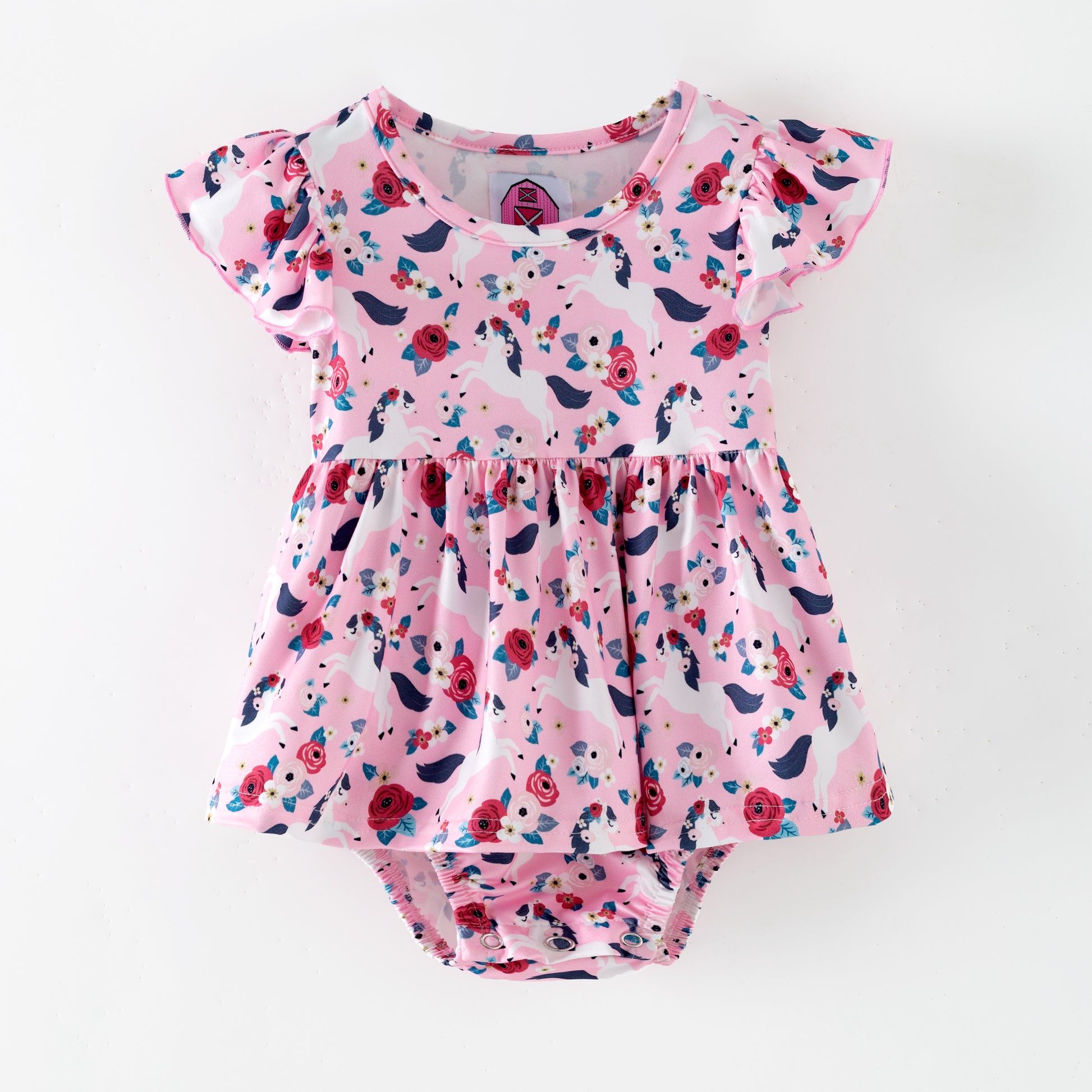 Pink floral baby romper with white horses on a pink background