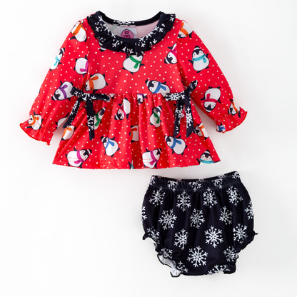 Two piece outfit with penguins on a red background and black snowflake bloomers