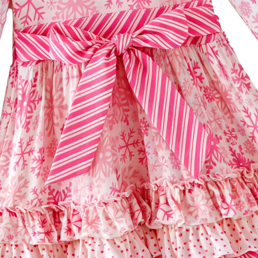 Pink and white snowflake dress with ruffled layers on a white background