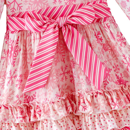 Pink and white snowflake dress with ruffled layers on a white background