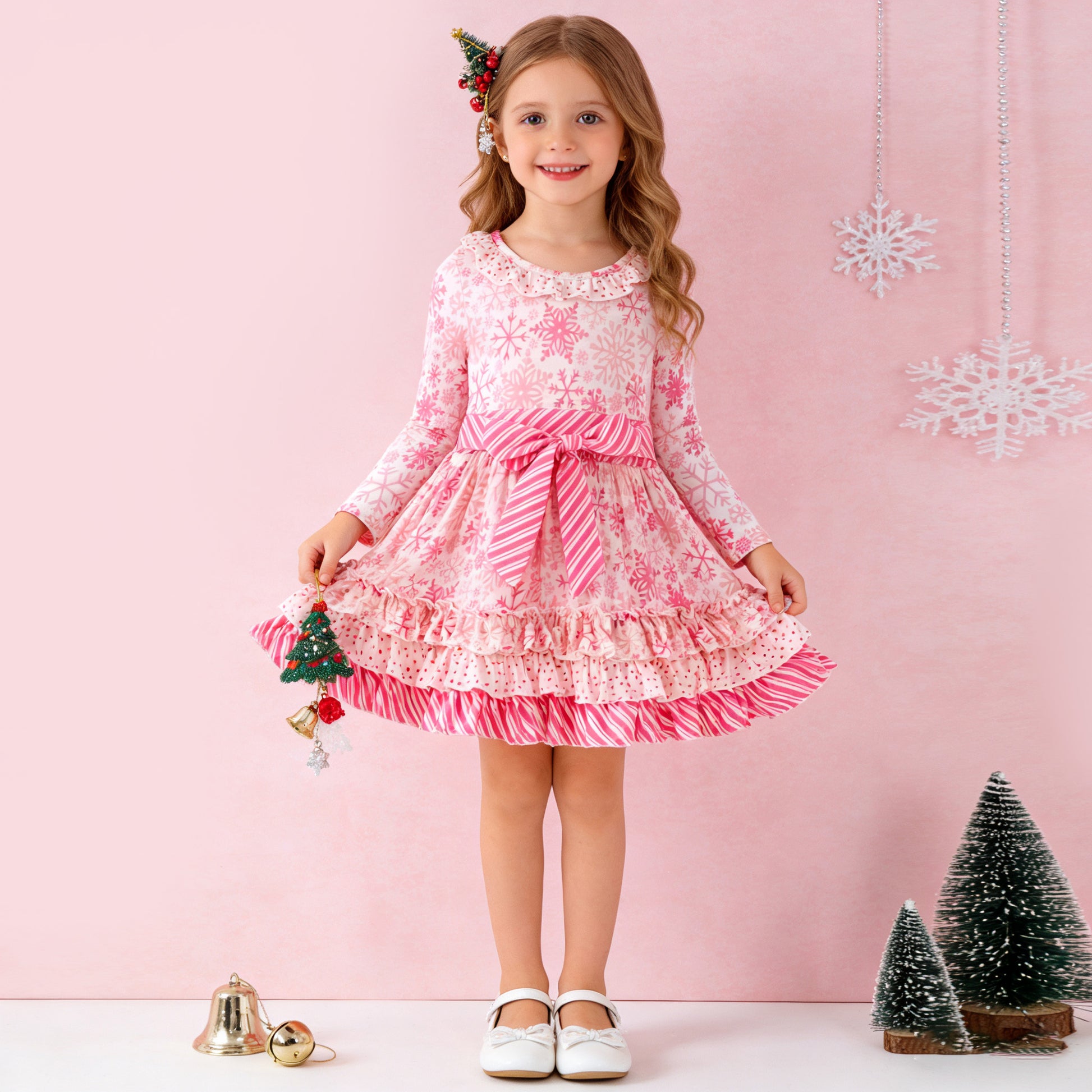 Young girl in a pink and white dress with Christmas decorations on a pink background