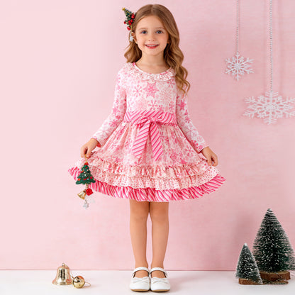 Young girl in a pink and white dress with Christmas decorations on a pink background