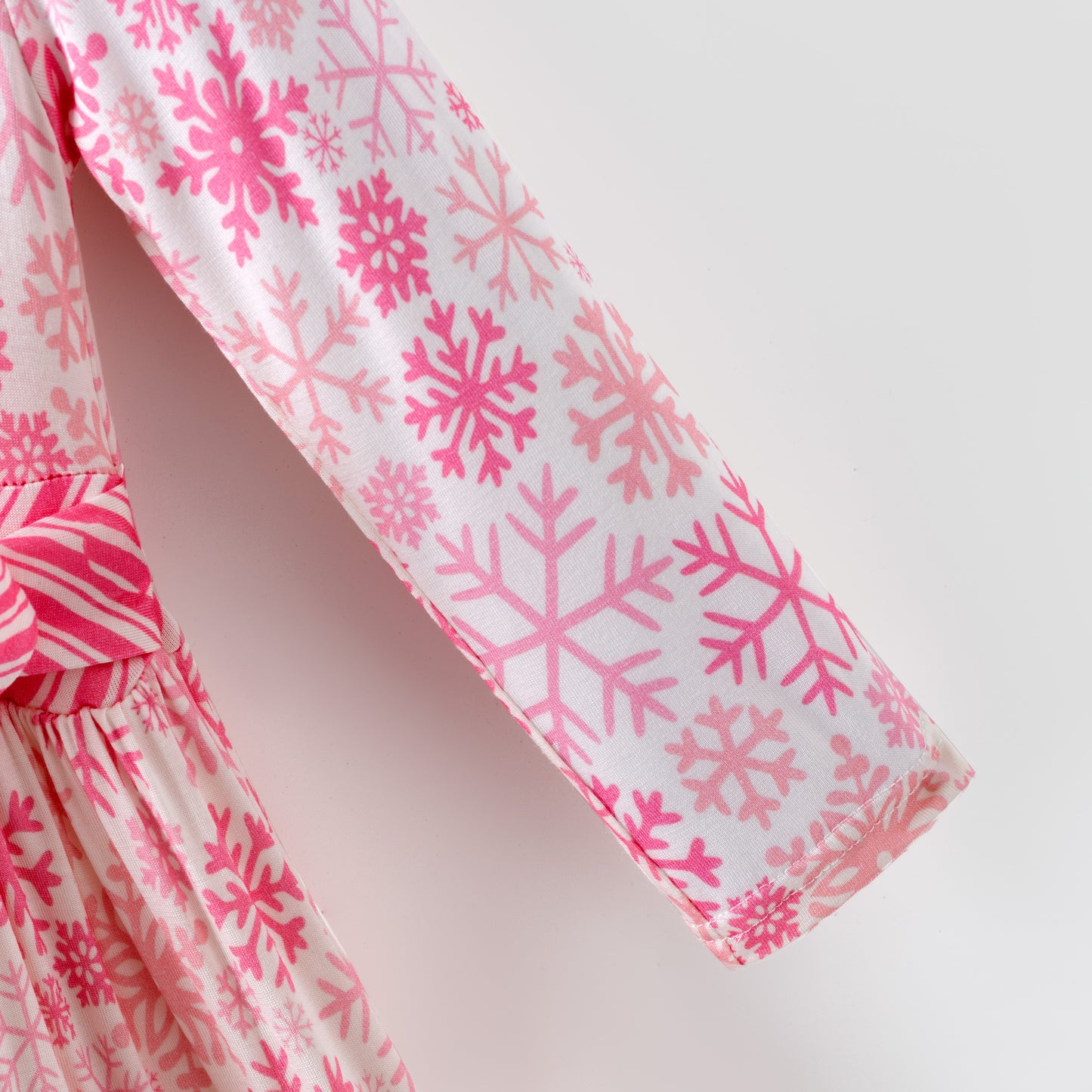 Pink and white snowflake dress with ruffled layers on a white background