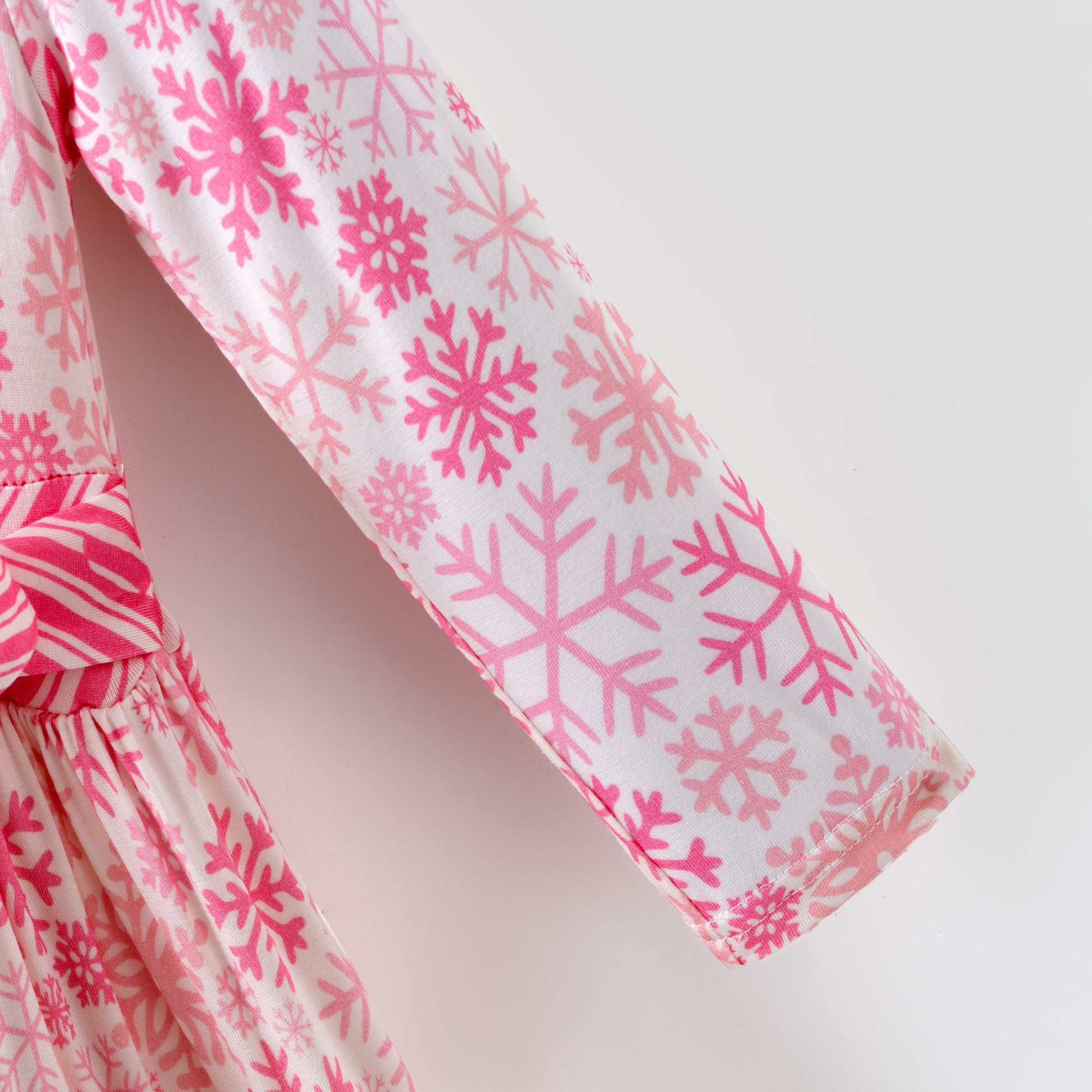 Pink and white snowflake dress with ruffled layers on a white background