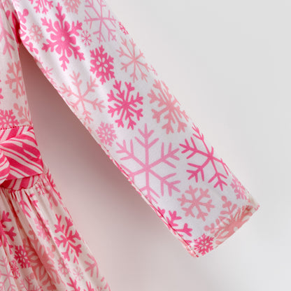 Pink and white snowflake dress with ruffled layers on a white background