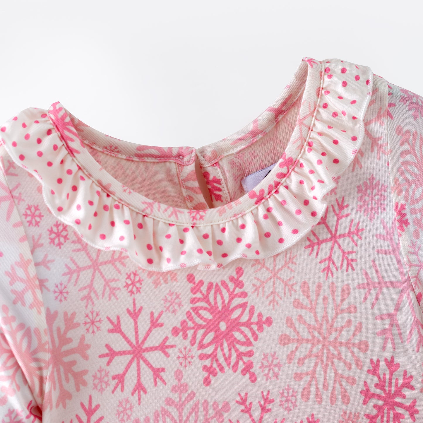Pink and white snowflake dress with ruffled layers on a white background