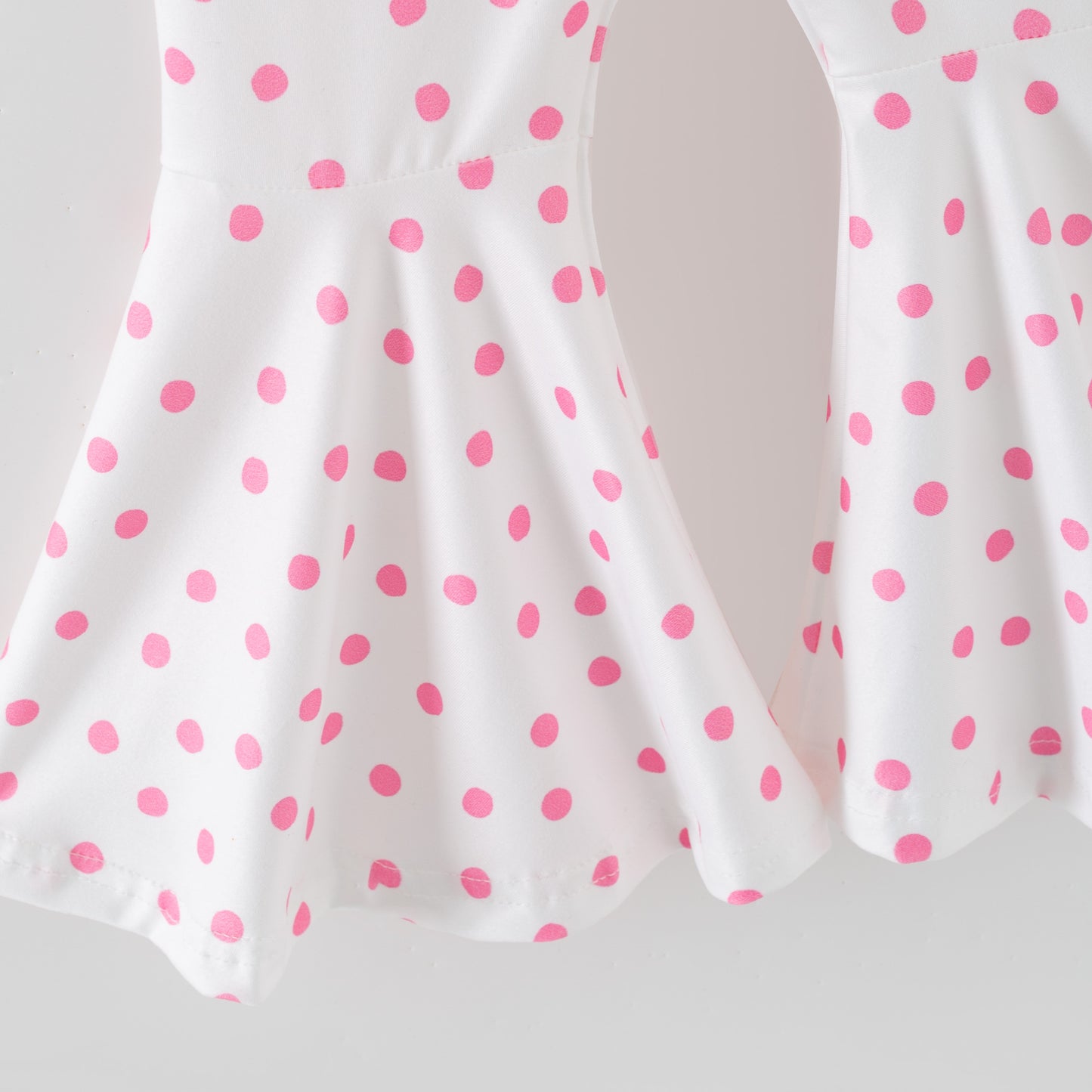 White pants with pink polka dots on a white background