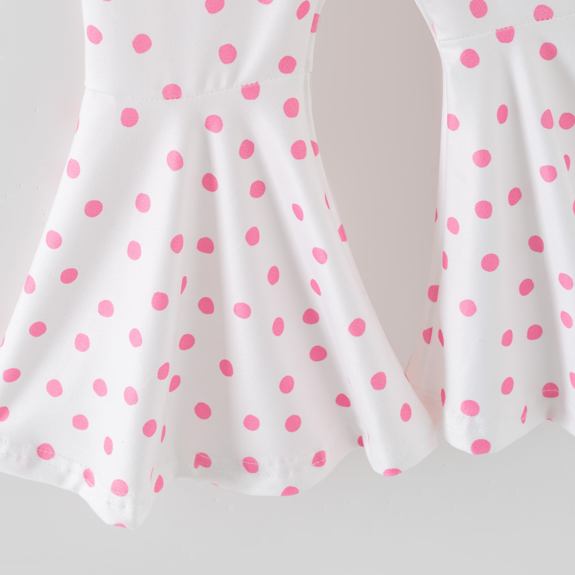 White pants with pink polka dots on a white background